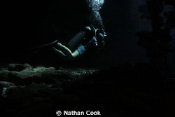A diver in a swim through on Iron Shore Gardens, Grand Ca... by Nathan Cook 